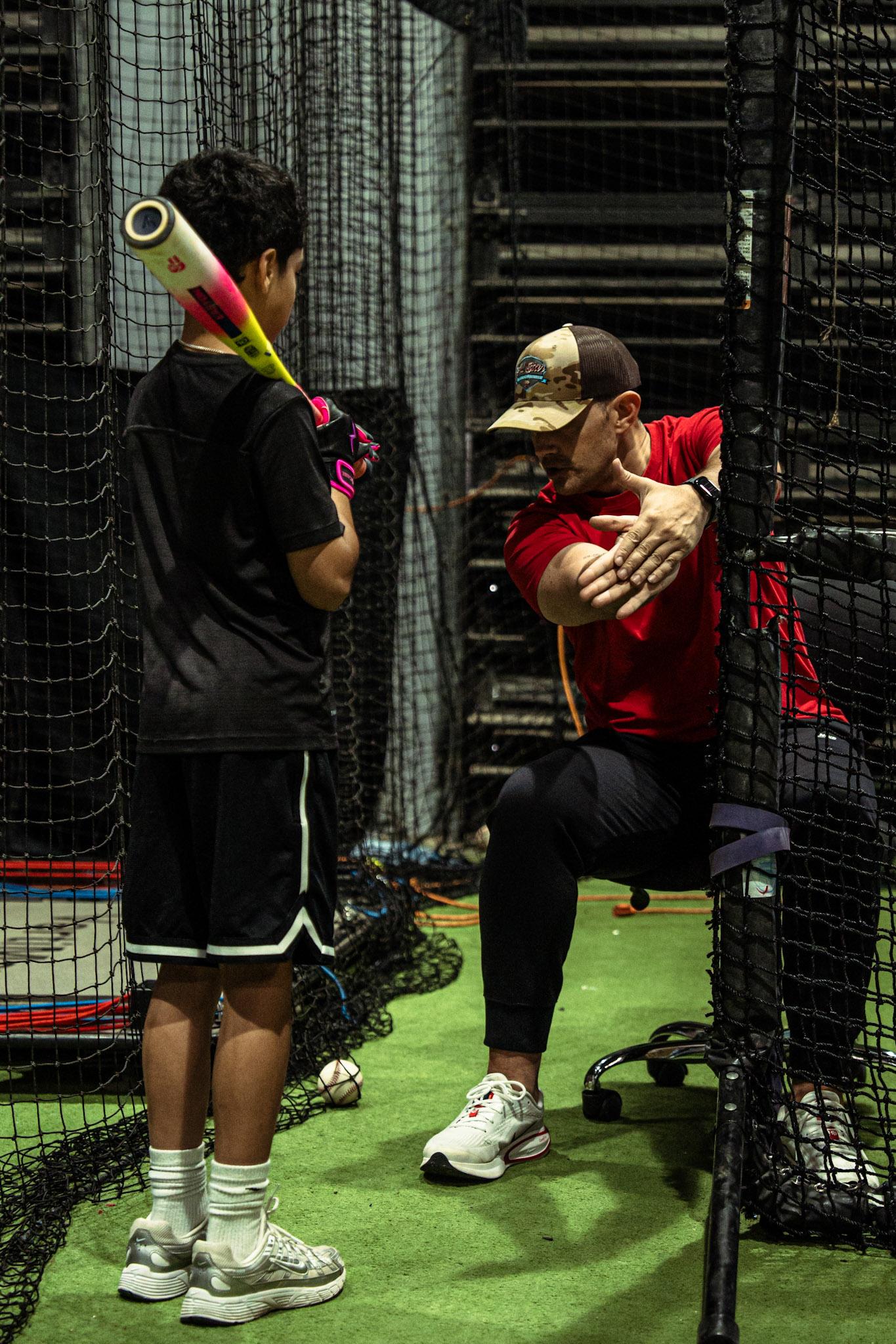 Coach providing one-on-one hitting instruction