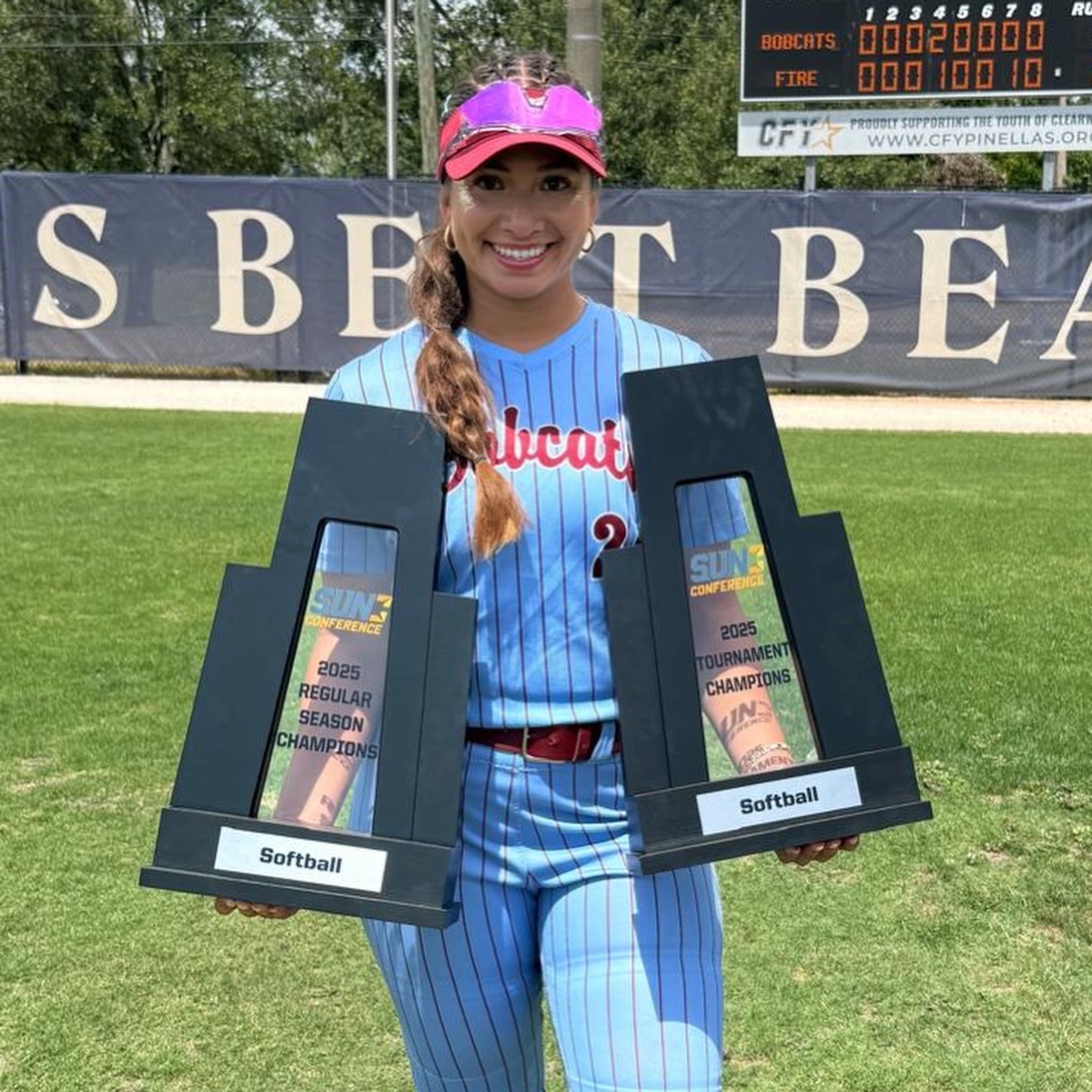 Alyssa Luna holding her 2025 Sun Conference softball championship trophies